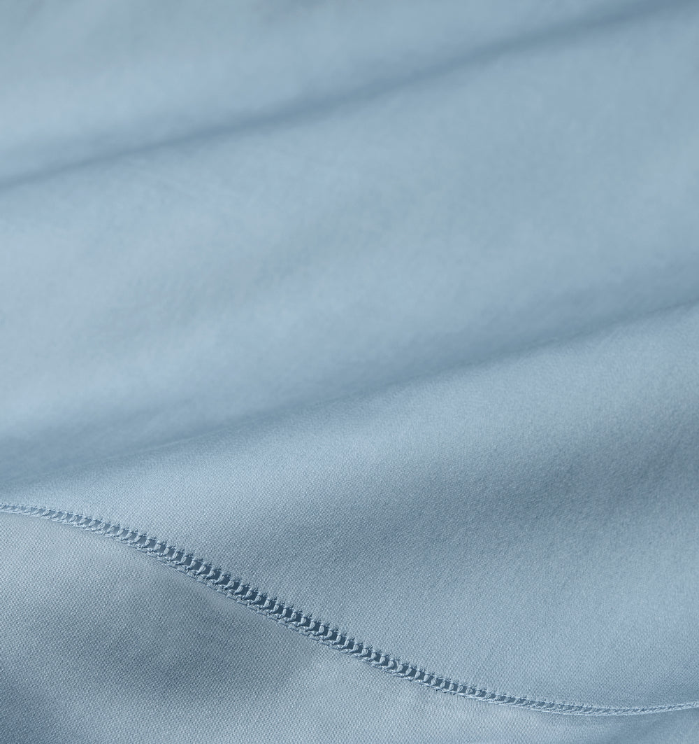 Close-up of light blue fabric with a visible seam
